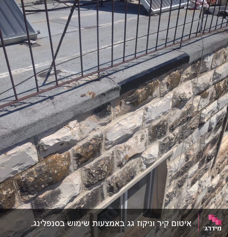 קיר אבן עם חלונות וסורגים על גג שטוח